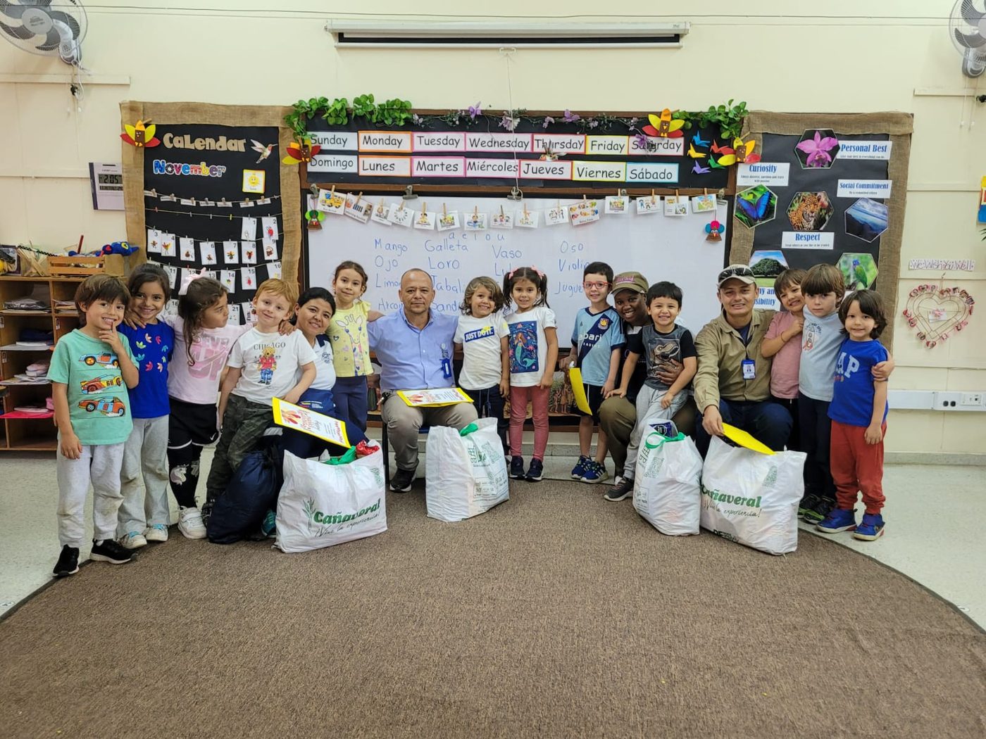 Grupo de niños y maestros con bolsas de anchetas